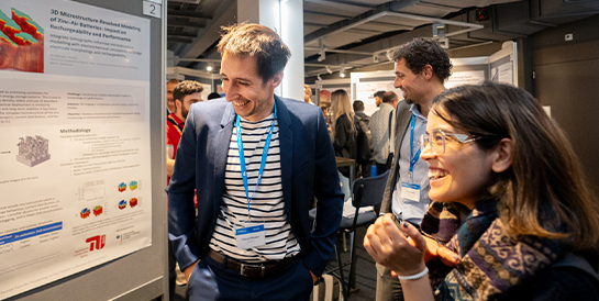 COMSOL Conference attendees having a conversation in the exhibition hall.