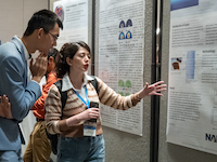 Attendees in the poster hall discuss multiphysics simulation at the 2024 COMSOL conference in Boston.