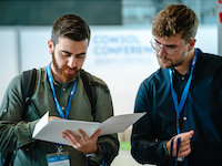 Zwei Teilnehmer der COMSOL Conference 2024 in Florenz gehen Unterlagen durch.