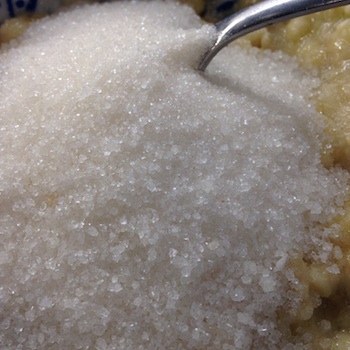 White sugar being mixed in with other ingredients.