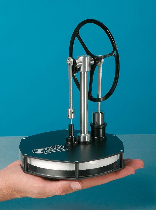 A photograph of a Stirling engine operating with heat from a human hand.