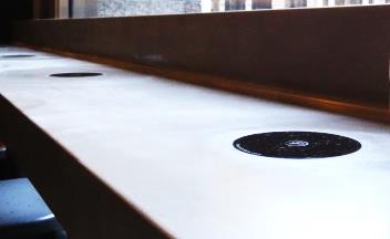 An image showing wireless charging spots on a coffee shop counter.