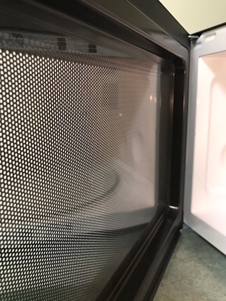 A photo showing the mesh screen of a microwave oven.