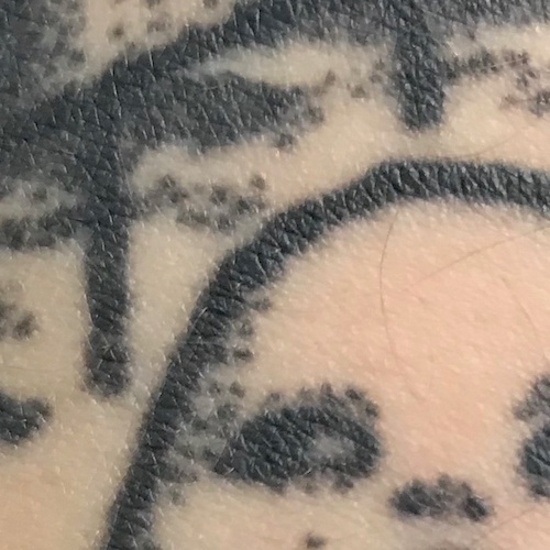 A closeup picture of tattoos created with black ink.