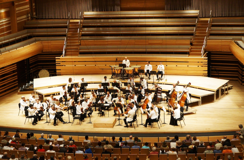 A photograph of classical musicians onstage at a concert.