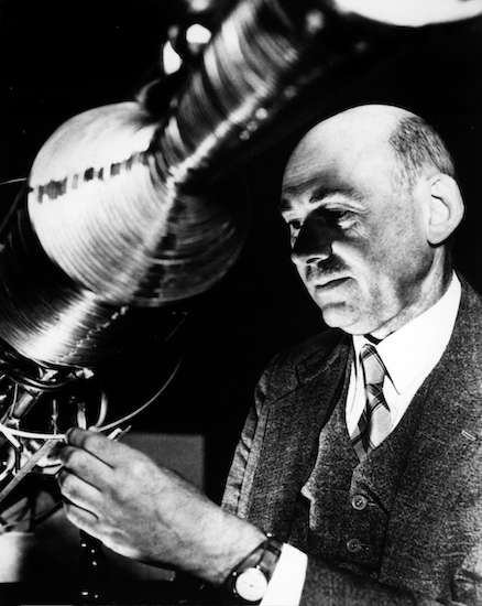 A photograph of Robert Goddard working on a rocket.