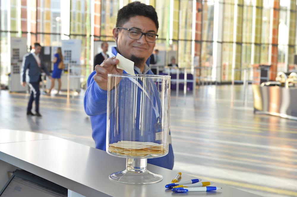 Photograph of a conference attendee voting during the poster session.