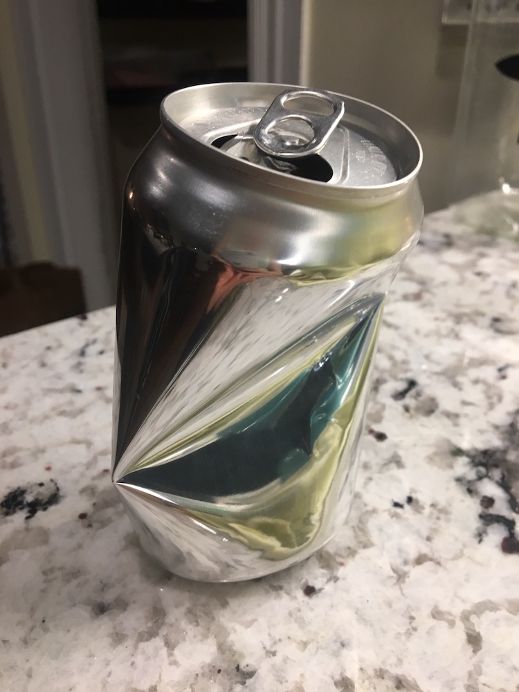 A photograph of a soda can after buckling.