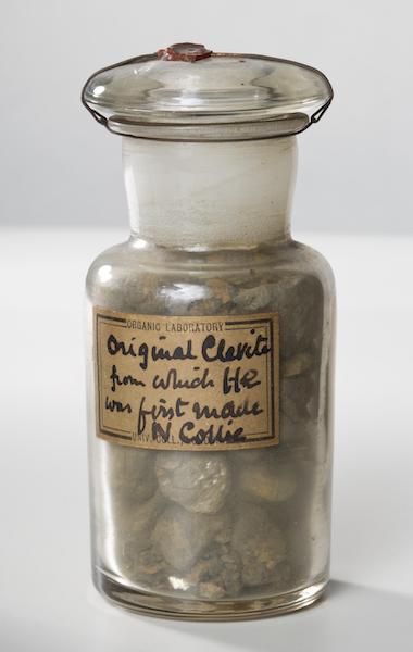 A photograph of a sample of cleveite in a jar.