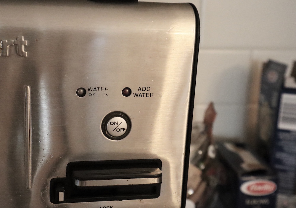 A photo of a coffee maker that looks like a face.