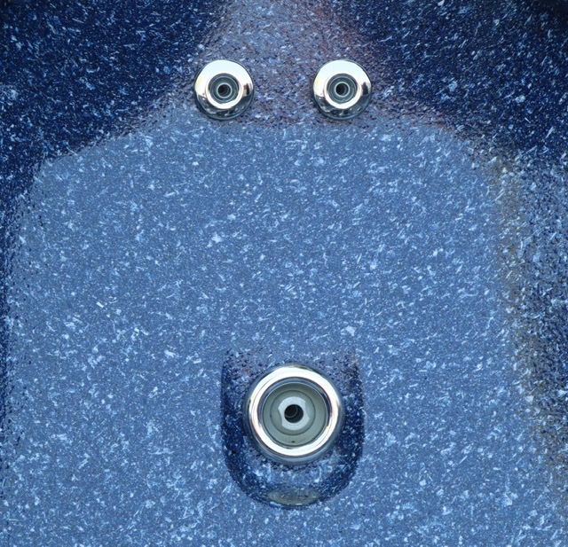 A closeup photograph of hot tub jets forming what looks like a human face, an effect called pareidolia.