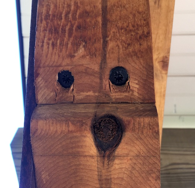 A photograph of a piece of wood with the swirls and knots forming what looks like a face.