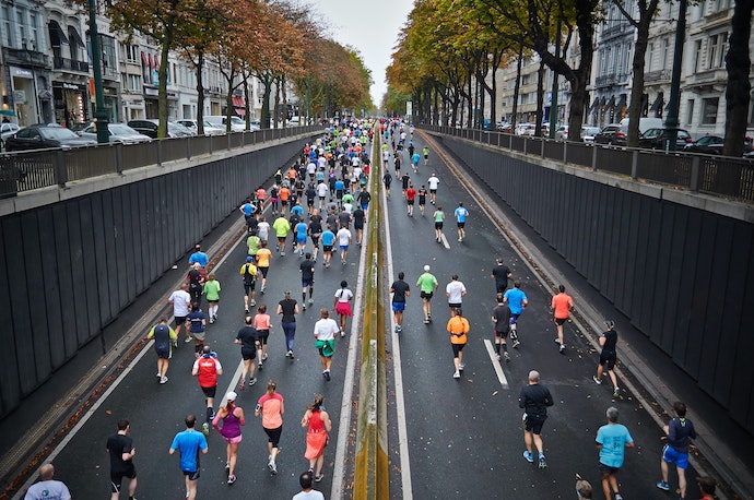 A photograph of a group of marathon runners outdoors on a paved street.