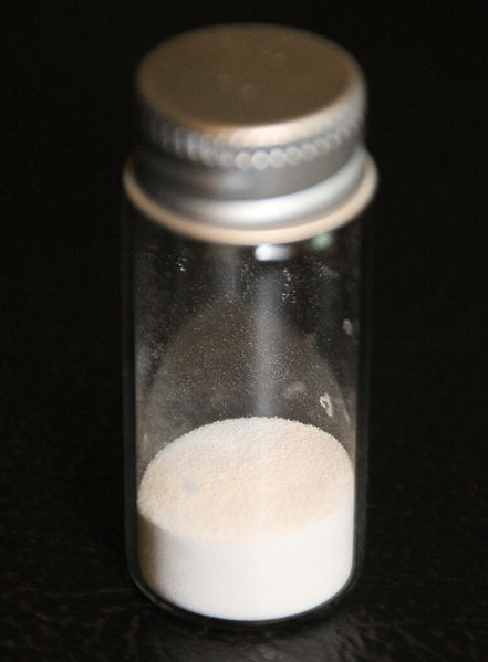 A photograph of a clear bottle of pure polyvinyl chloride in the form of a white powder.