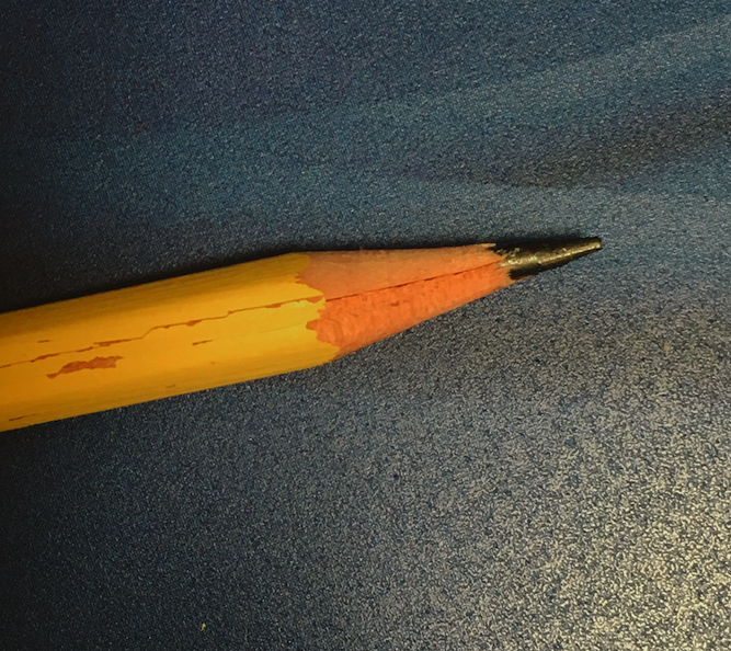 A photograph of the sharpened point of a typical yellow pencil.