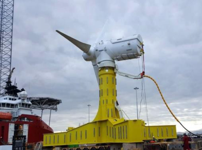 A wide shot of a white and yellow tidal turbine on a dock.