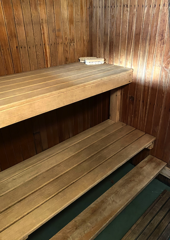 A vintage dry sauna with two wooden benches at different heights.