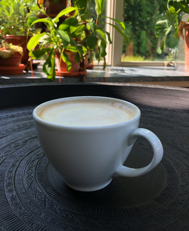 A cappuccino in a white teacup.