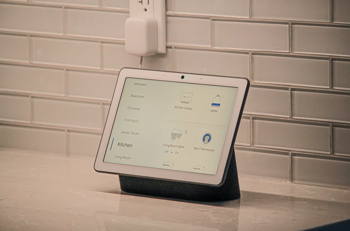 A white tablet with a screen on a marble counter.