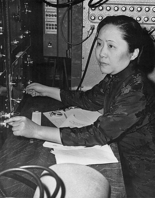 A black and white photograph of Chien-Shiung Wu touching equipment in a laboratory.
