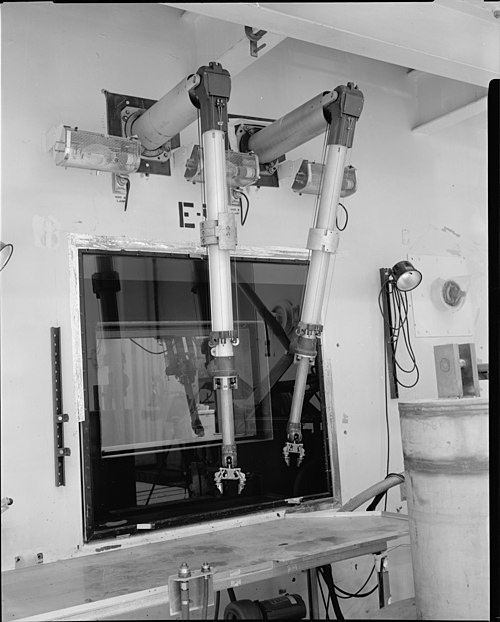 A black and white photograph of a remote manipulator at a test site.